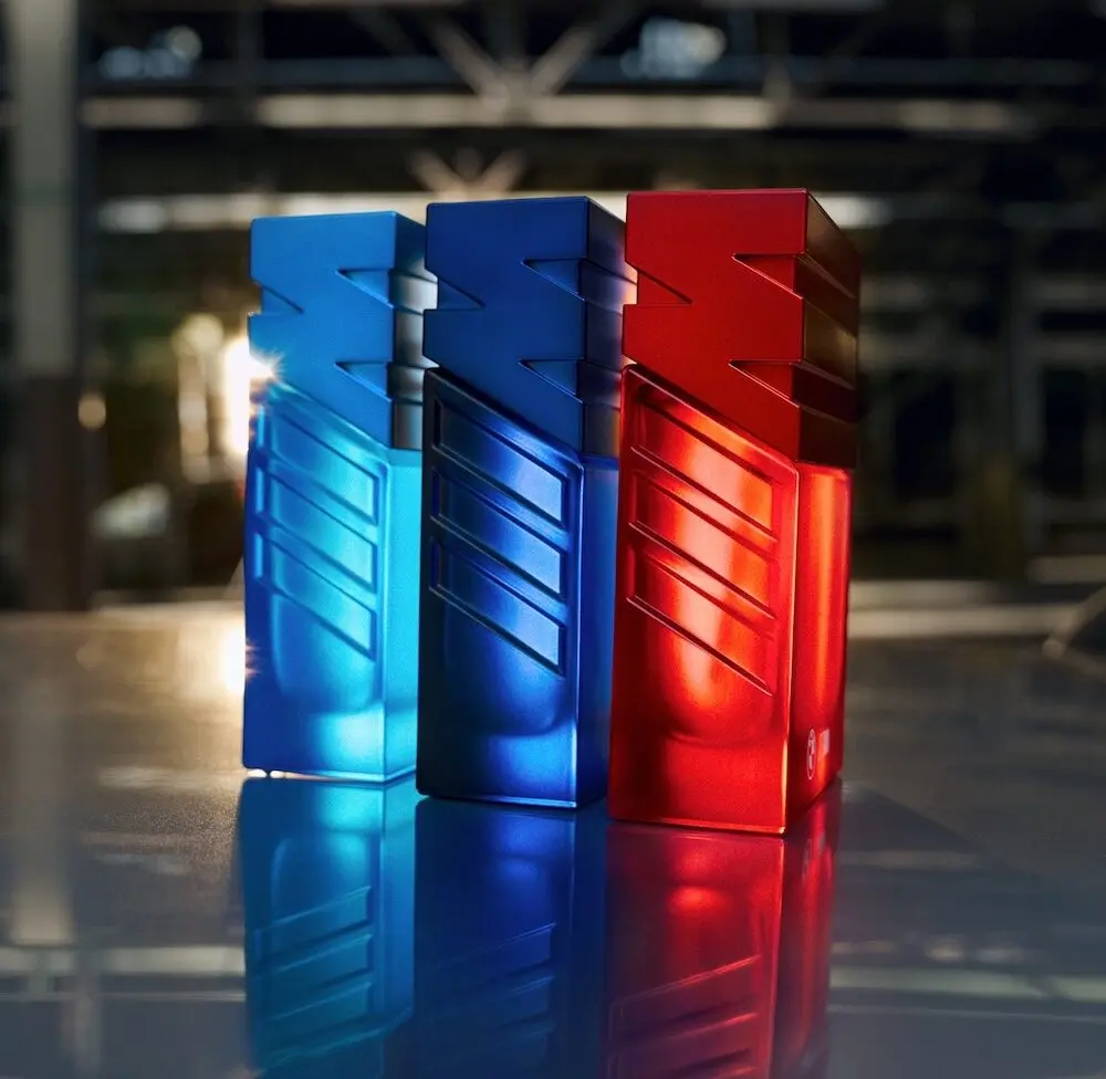 Trois flacons de parfum colorés aux teintes bleues et rouges de la collection BMW Motorsport.