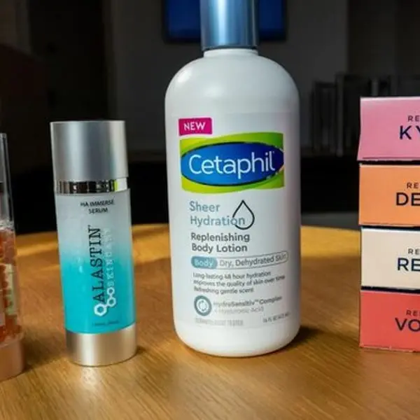 Produits de soins présentés sur une table, notamment une lotion hydratante Cetaphil, reflétant les prévisions de Galderma
