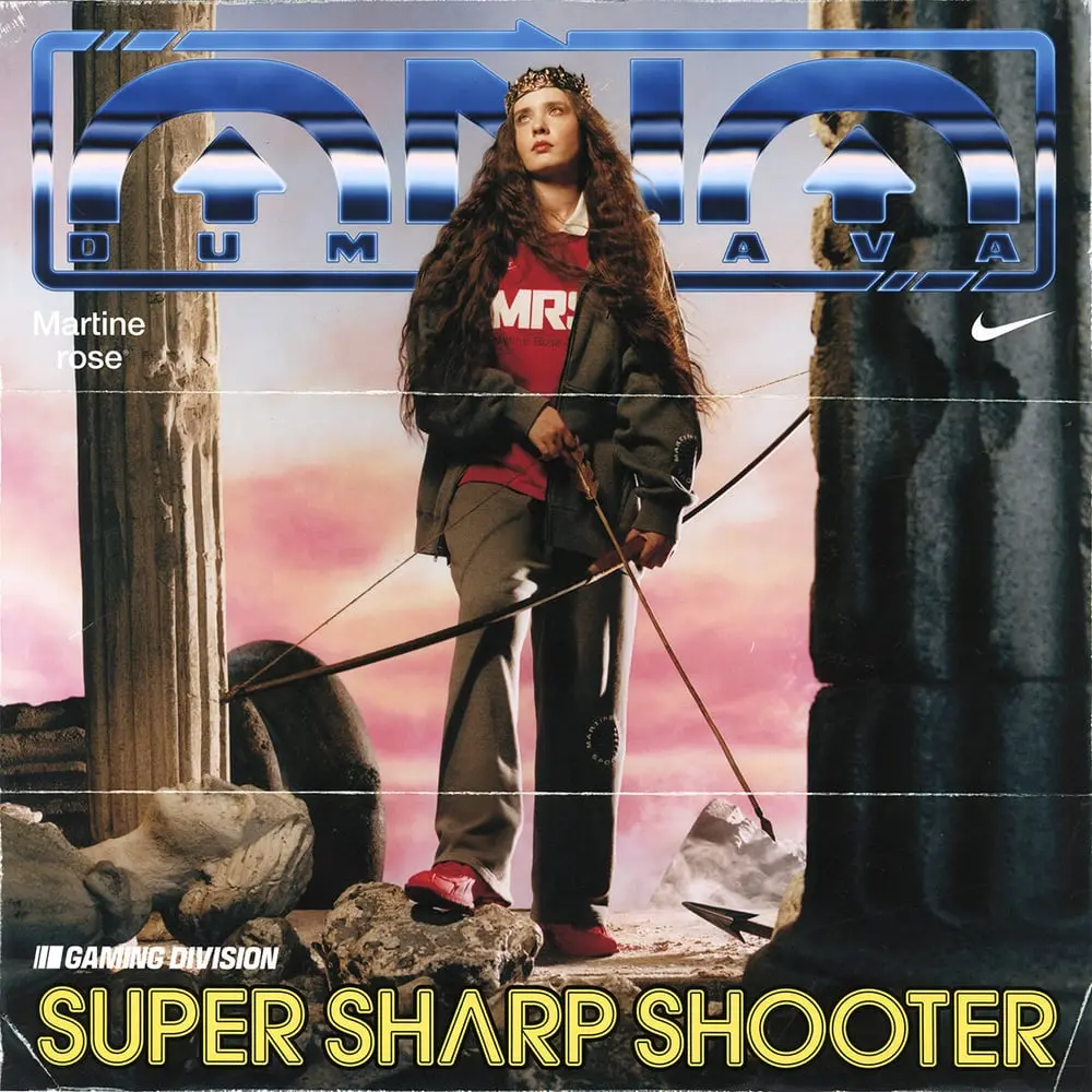 Modèle en vêtements décontractés Martine Rose posant avec un arc entre des colonnes antiques, ambiance gaming