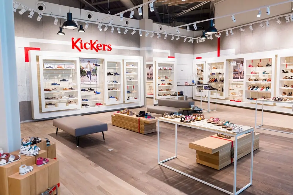 Magasin Kickers avec présentoirs de chaussures colorées, marques du Royer Group
