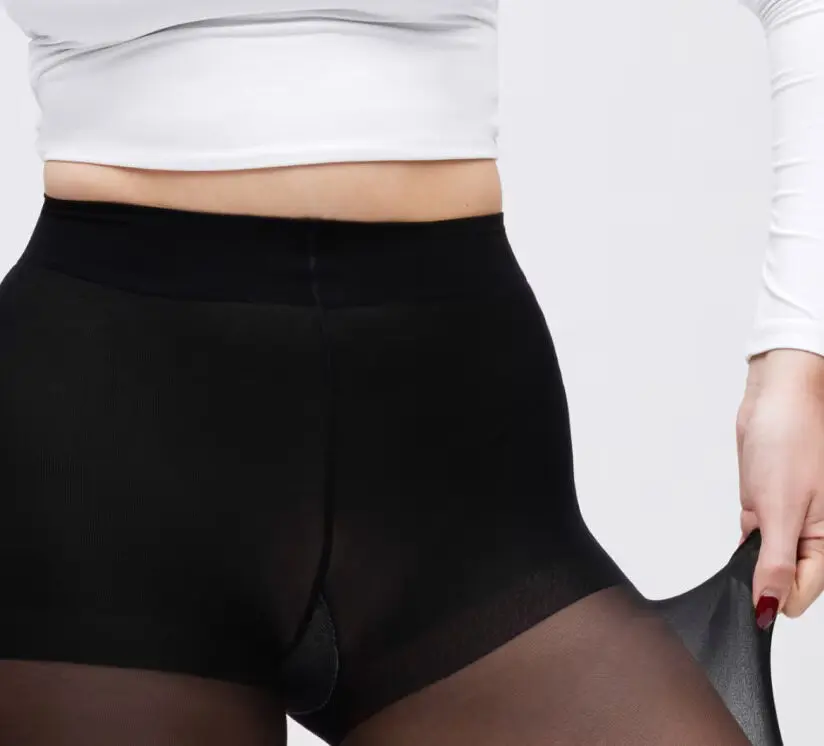 Une personne teste la résistance d'un collant noir Sheertex en l'étirant avec sa main droite