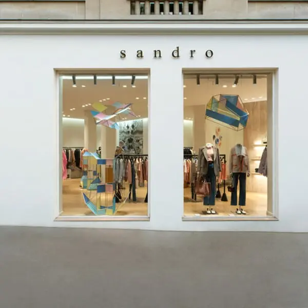 Vitrine du magasin Sandro avec des vêtements exposés et décor géométrique coloré.