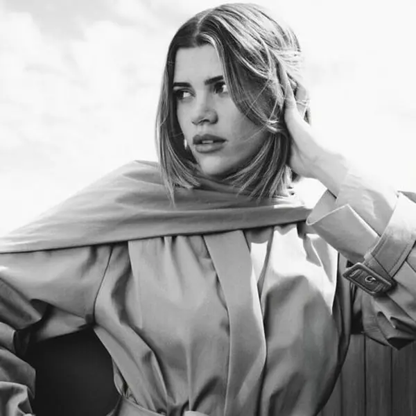 Femme portant un trench-coat élégant associée à la collection mode de Sofia Richie Grainge pour Revolve