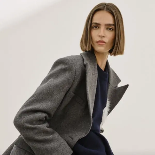Modèle posant dans un manteau gris de The Couture Club, illustrant une stratégie SEO mode élégante