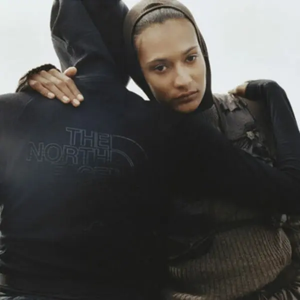 Personnes en vêtements The North Face, l'une portant un sweat à capuche, bras posés sur les épaules de l'autre.