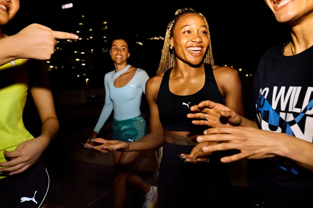 Groupe de jeunes en tenue Puma discutant et riant joyeusement en extérieur la nuit