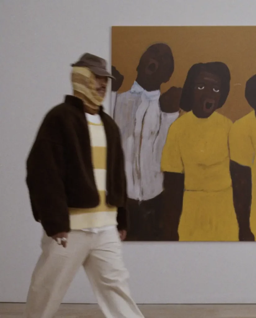 Personne marchant devant une peinture expressive lors de la collaboration mode Axel Arigato avec Alvin Armstrong