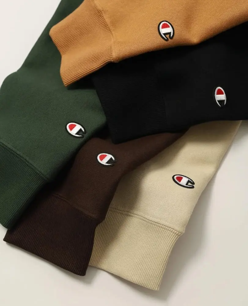Manches de sweats de différentes couleurs avec logo Champion visibles en gros plan