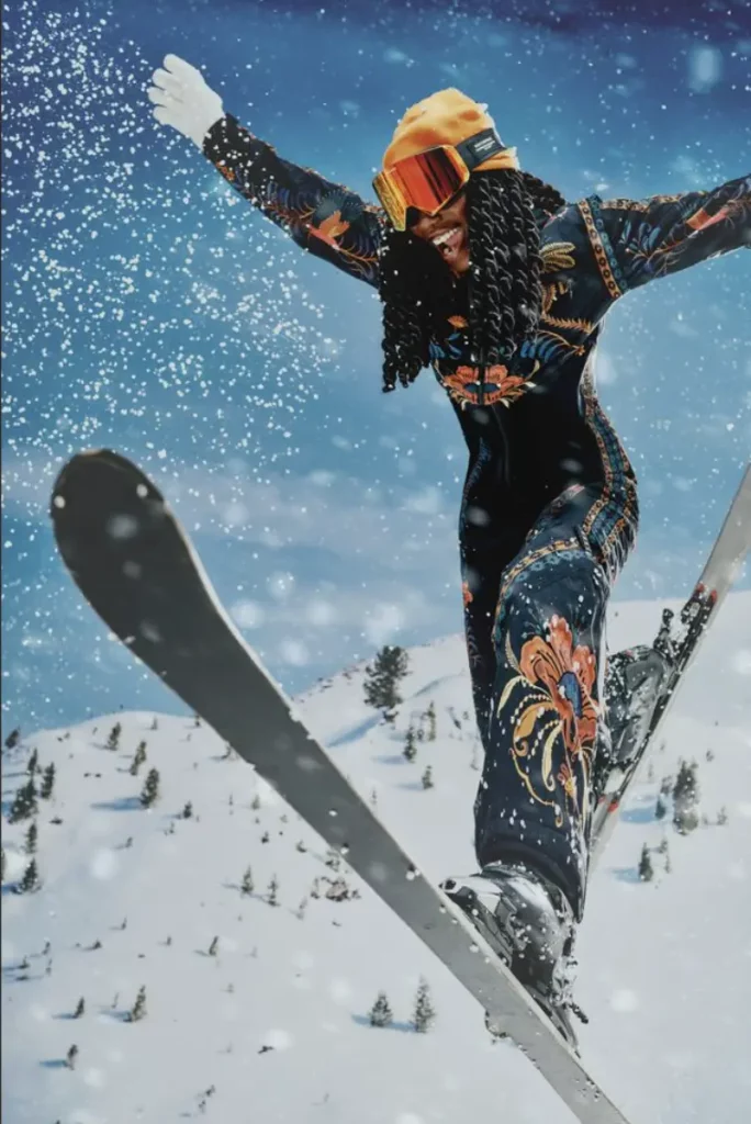 Skieuse en combinaison colorée Farm Rio dévalant une piste enneigée, entourée de flocons et montagnes