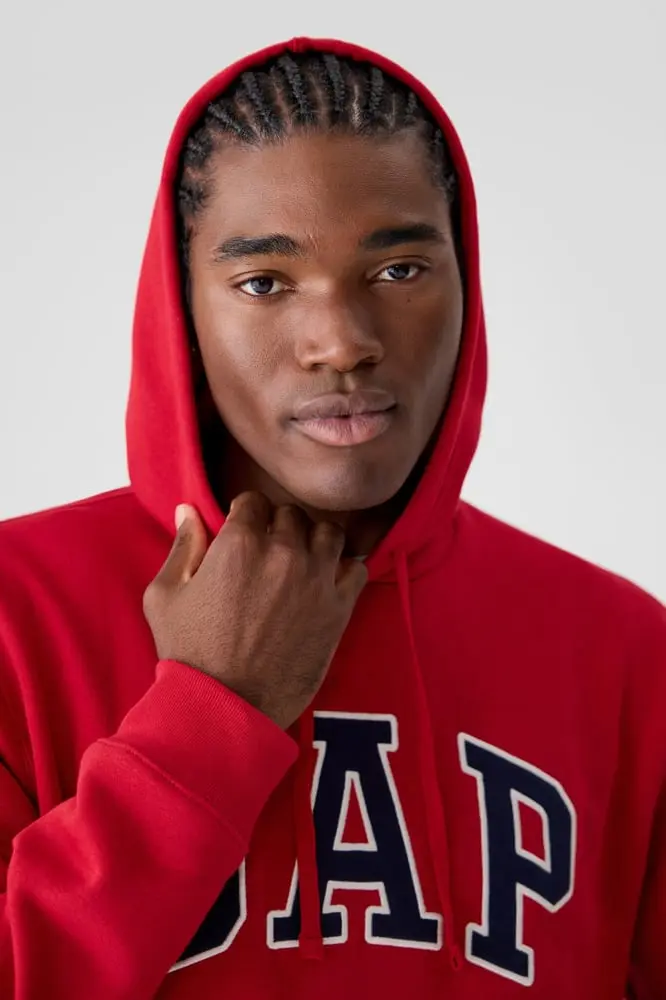 Homme portant un sweat à capuche rouge avec le logo Gap en gros plan