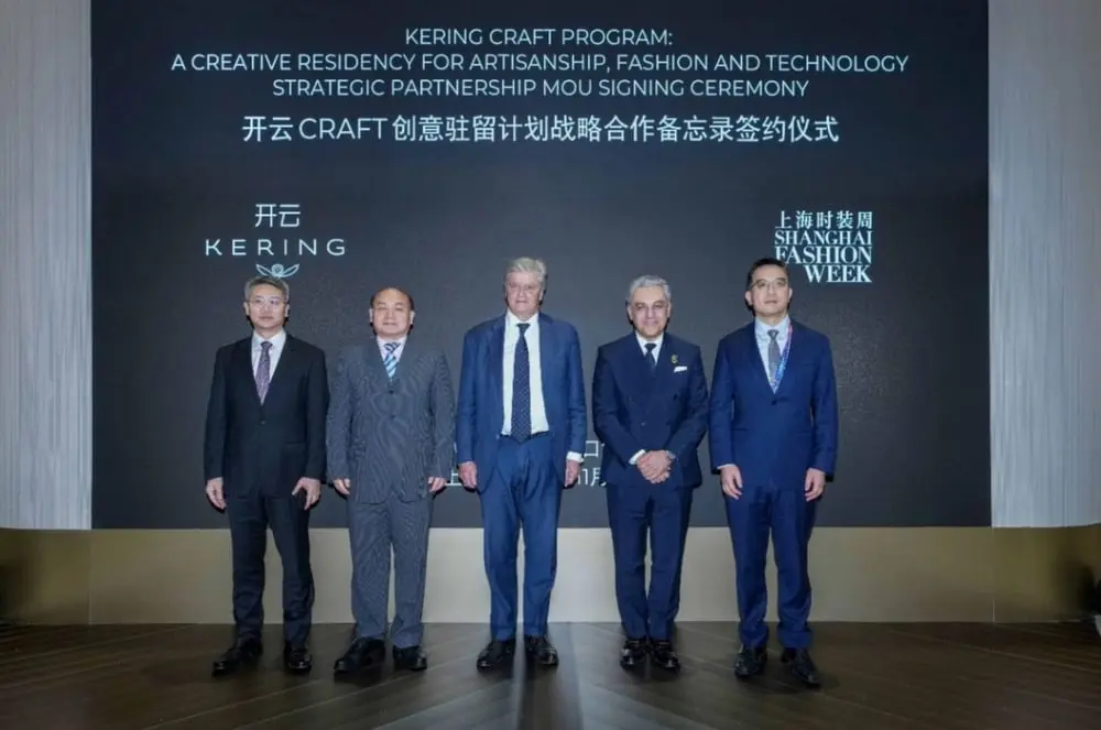 Des dirigeants posent devant le panneau de l'accord Kering Craft en Chine lors de la Shanghai Fashion Week