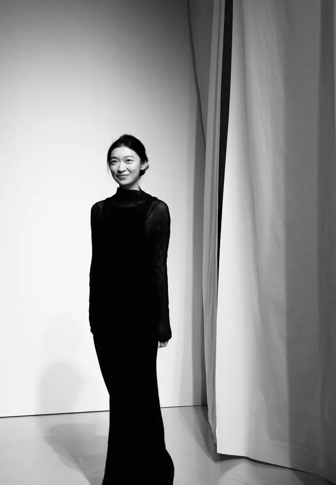 Créatrice chinoise Ruohan Nie en robe noire posant à la Fashion Week Paris