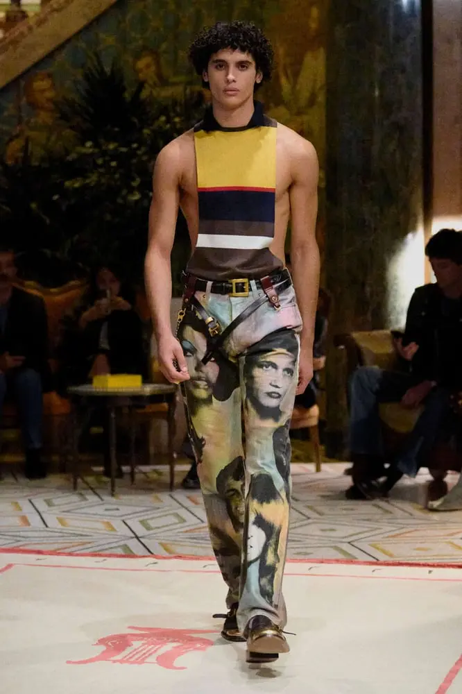 Mannequin défilant en tenue colorée avec pantalon imprimé Versace lors d'un événement Prada.