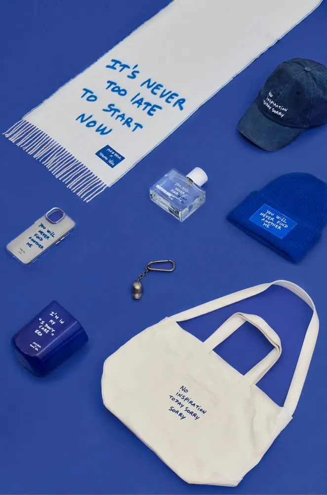 Accessoires Pull&Bear avec textes en bleu sur fond bleu, incluant écharpe, casquette, bonnet, sac et étui de téléphone