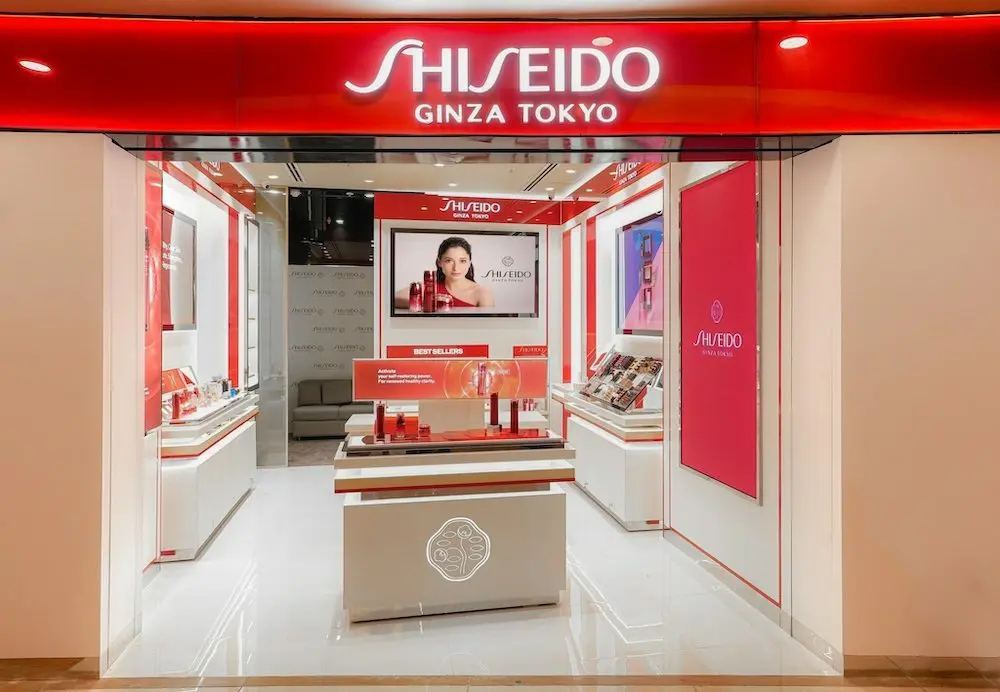 Boutique Shiseido Ginza Tokyo avec présentoirs produits et affiches promotionnelles dans un décor moderne et lumineux