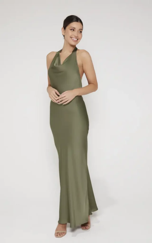 Femme souriante en robe longue verte posant dans un studio, proposée par SilkFred