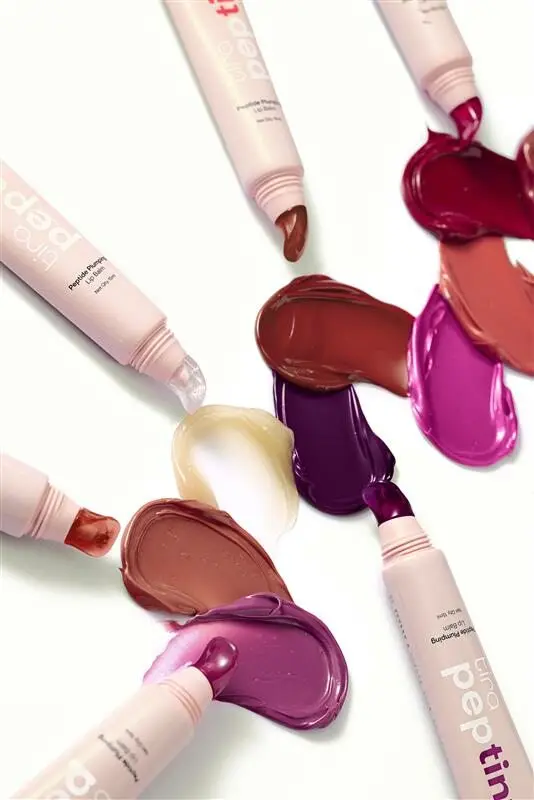 Rouges à lèvres Tira Peptint étalés, tubes ouverts, diverses teintes vives, lancement du maquillage phare de Tira