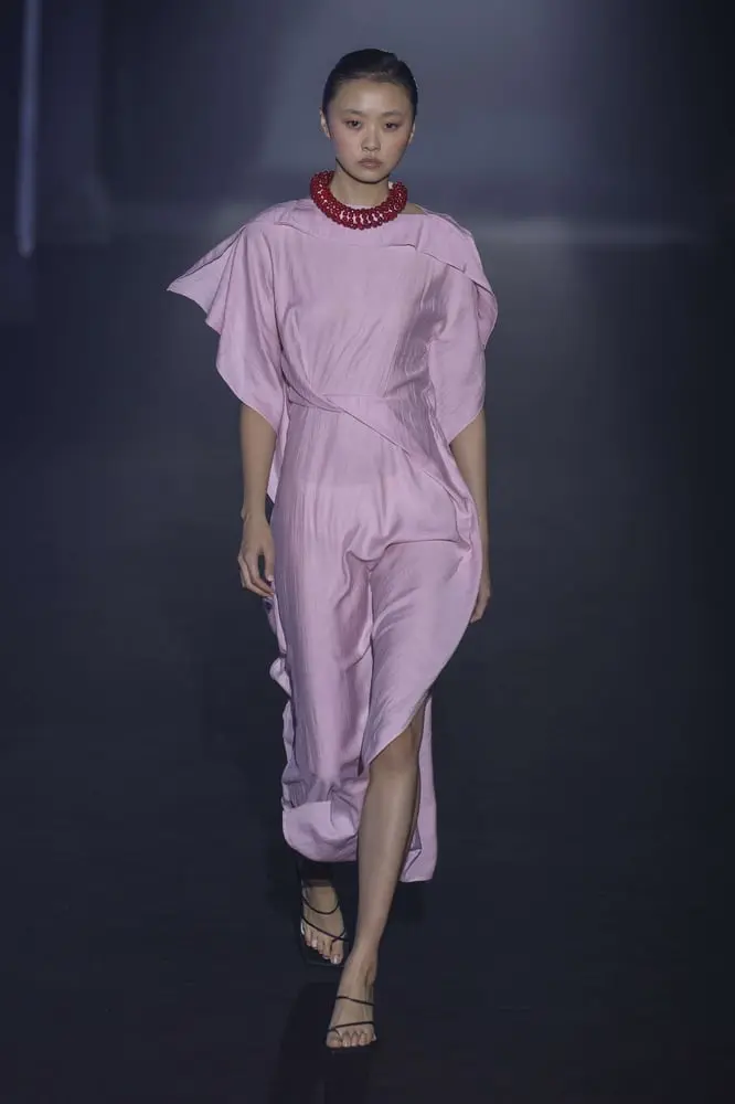 Mannequin en robe rose et collier rouge défile lors de l'événement 080 Barcelona Fashion