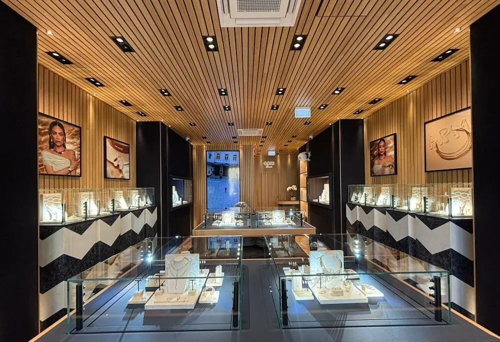 L'intérieur élégant d'une boutique APM Monaco avec bijoux exposés et décor boisé lumineux