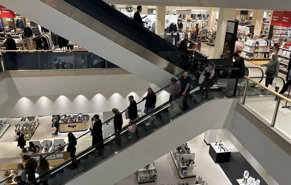 Des clients descendent un escalator dans un grand magasin pendant le Boxing Day au Royaume-Uni.