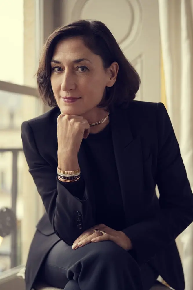 Femme en tailleur noir assise près d'une fenêtre, regard pensif, symbole de leadership du Comité Colbert