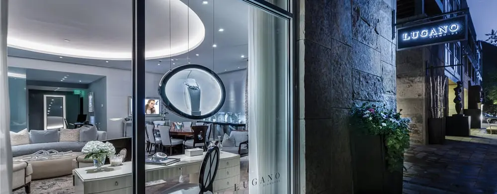 Une vitrine de Lugano Diamonds illuminée, montrant un intérieur élégant avec des meubles contemporains.