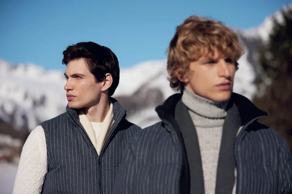 Deux hommes en tenues hivernales stylées, regardant au loin devant des montagnes enneigées, illustrant Goodfellas.
