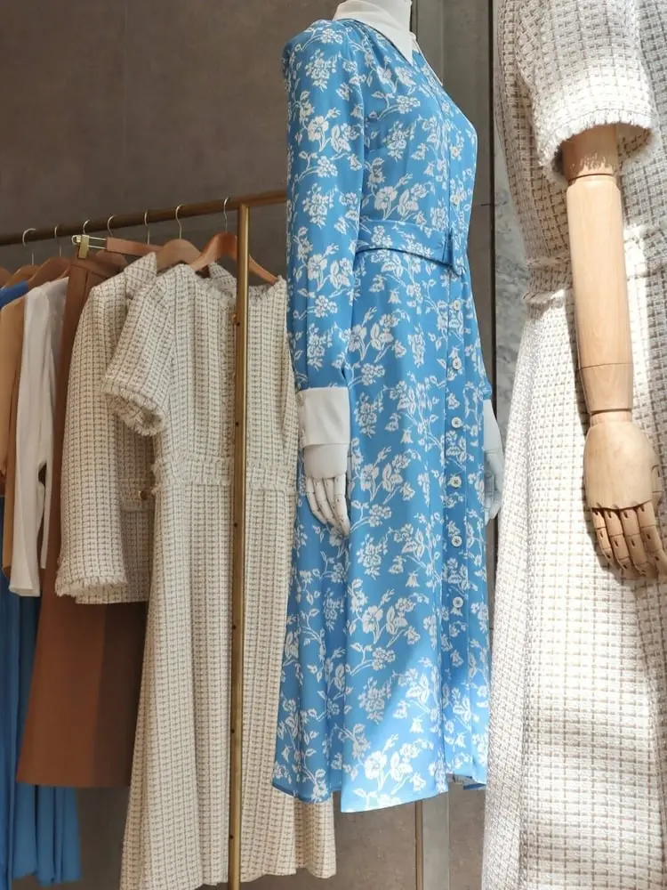 Mannequins en robes élégantes de LK Bennett dans un magasin, incluant une robe bleue à motifs floraux