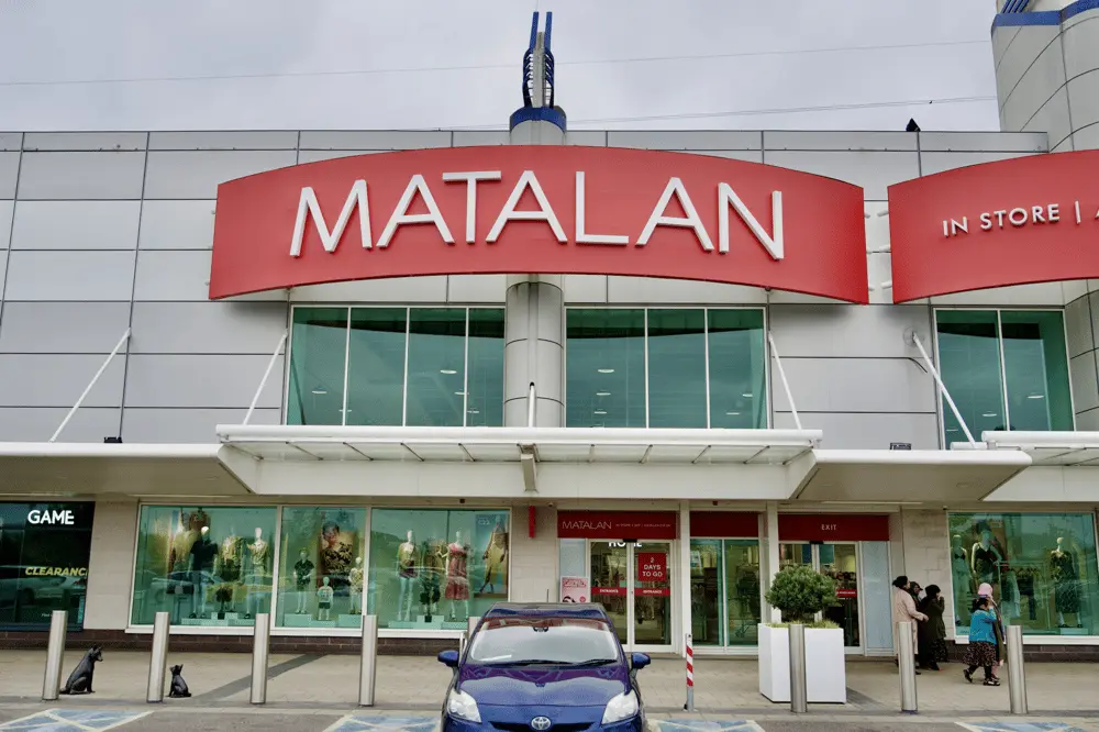 Façade moderne d'un magasin Matalan avec clients et voiture garée devant l'entrée principale