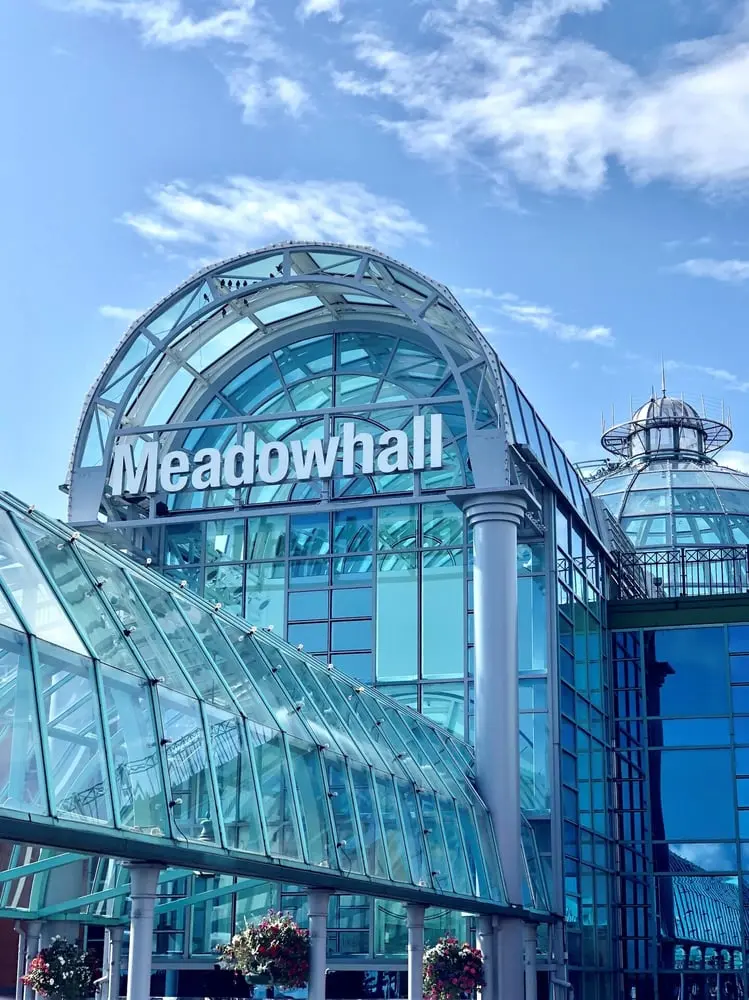 Façade en verre du centre commercial Meadowhall sous un ciel bleu à Sheffield