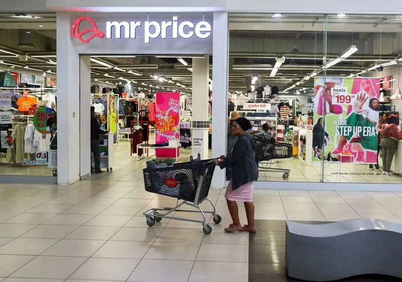 Devanture de magasin Mr Price avec une cliente poussant un chariot dans un centre commercial lumineux.