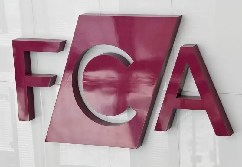 Logo FCA en rouge sur un mur blanc, symbolisant le régulateur financier britannique