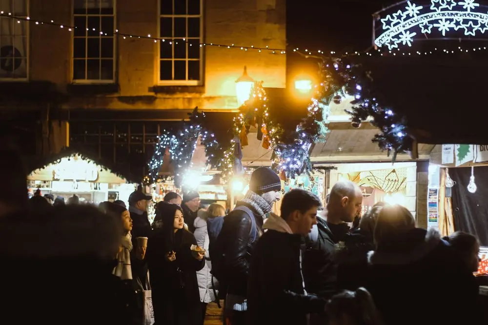 Foule animée dans un marché de Noël décoré, illustrant le shopping hybride des Britanniques pendant les fêtes
