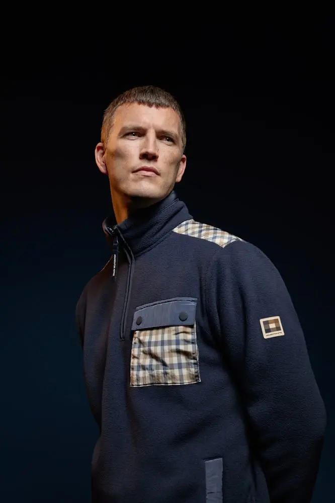 Homme portant une veste bleue Aquascutum Active avec un motif à carreaux, regardant vers la gauche
