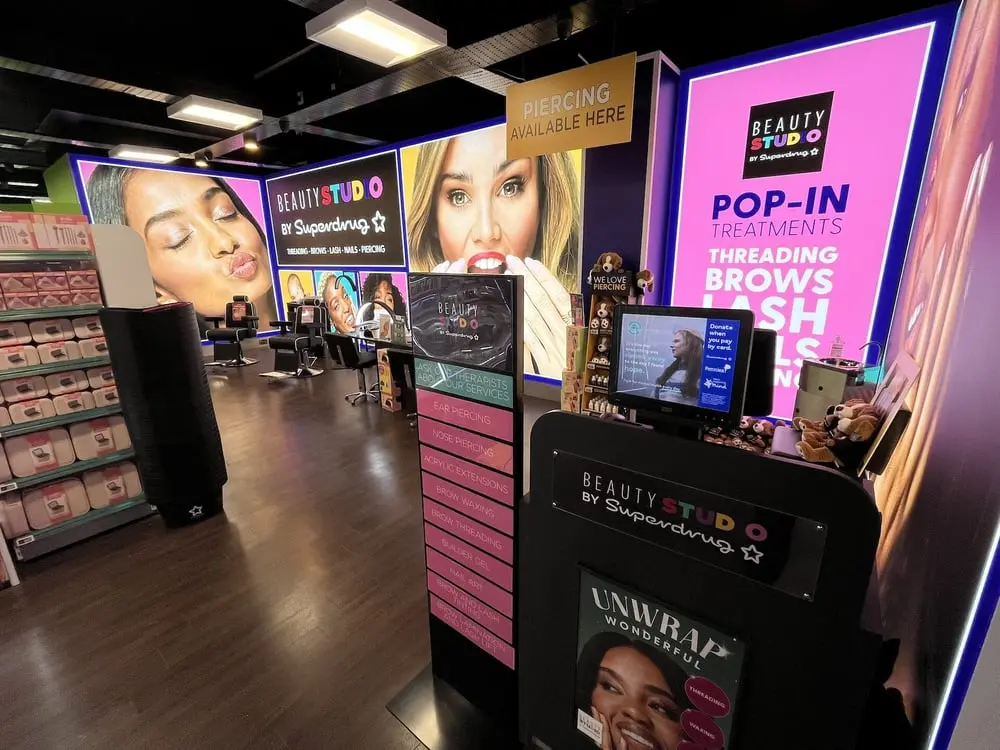 Intérieur d'un Beauty Studio de Superdrug avec affiches et services de beauté disponibles