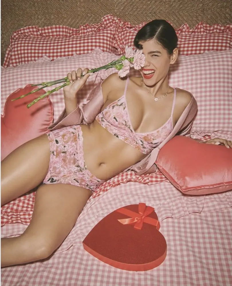 Modèle en lingerie florale Hanky Panky, allongée avec des fleurs et une boîte rouge en forme de cœur