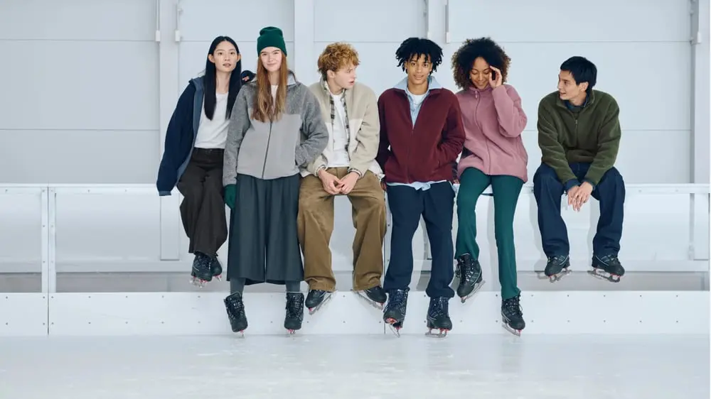 Groupe de jeunes sur une patinoire portant des vêtements d'hiver décontractés Uniqlo