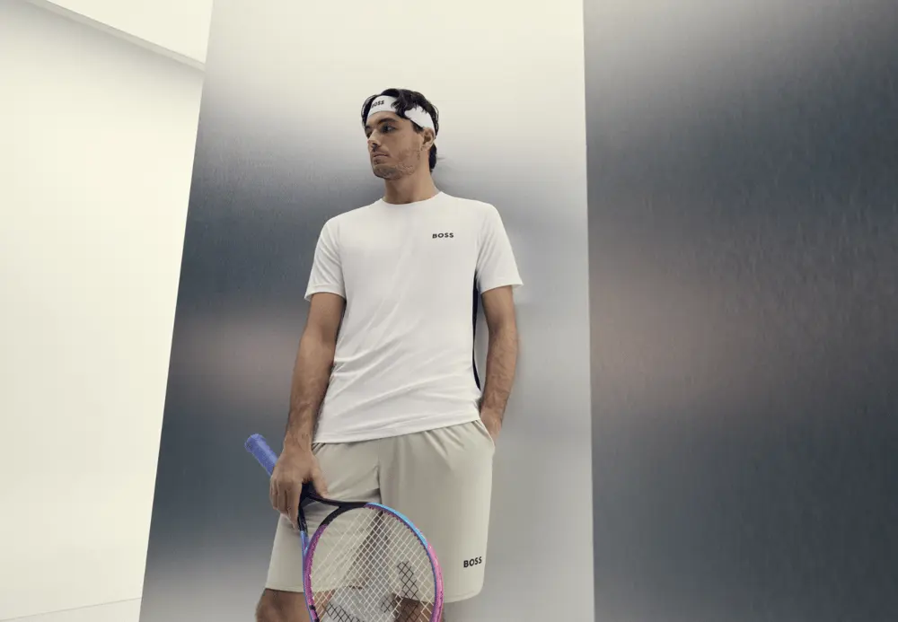 Un joueur de tennis en tenue Boss avec une raquette, illustrant la promotion du fil écoresponsable NovaPoly.