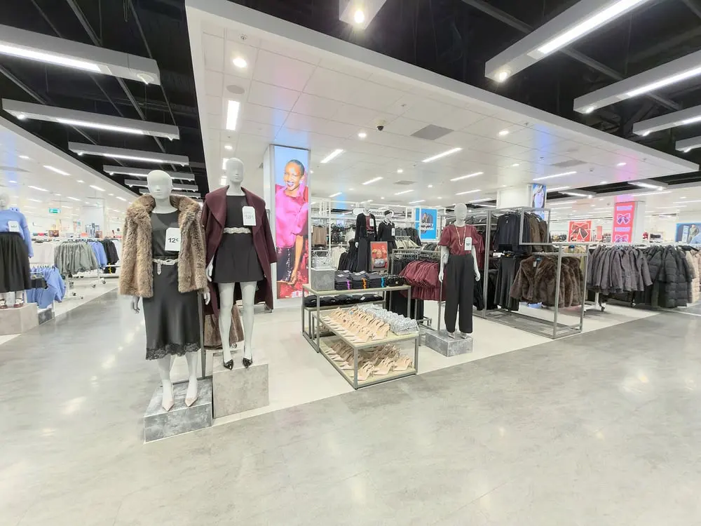 Mannequins habillés de vêtements élégants dans un magasin Primark au Royaume-Uni, entourés de divers rayons de vêtements