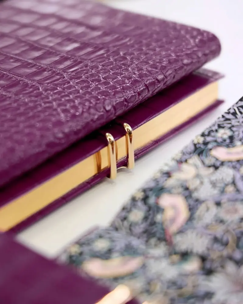 Carnet Smythson en cuir violet embossé et détaillé décoratif à motifs, bordé de pages dorées.